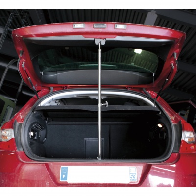 Mala traseira aberta de um carro vermelho com interior preto e suporte de haste de metal