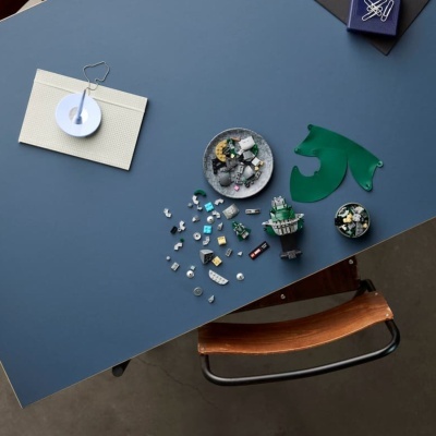 Peças de LEGO em cima de uma mesa azul com pratos e suporte branco com clipes metálicos