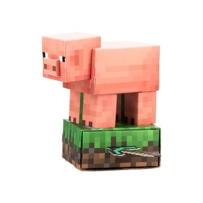 Figura de porco Minecraft pixelizada em papel sobre base quadrada de grama pixelizada.