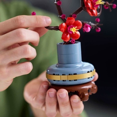 Vaso de plantas em blocos de construção plástico com flores vermelhas e rosa