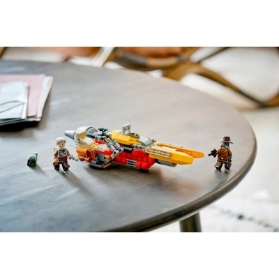 Brinquedo de construção com nave espacial amarela e vermelha e mini figuras humanas na mesa cinzenta