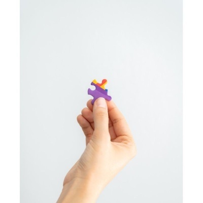 Mão segurando uma peça colorida de puzzle