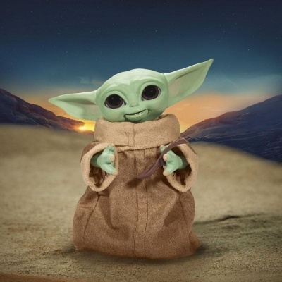 Boneco de pelúcia Baby Yoda num cenário desértico ao pôr do sol