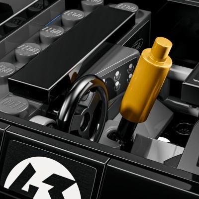 Peças LEGO formando interior de veículo com volante e alavanca dourada