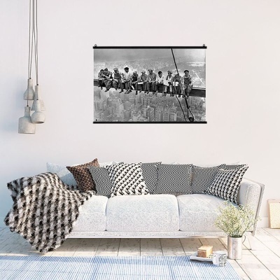 Sala de estar com sofá branco, almofadas padrão preto e branco e quadro a preto e branco na parede