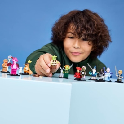 Mini-figuras de personagens coloridos alinhadas numa superfície branca com criança ao fundo