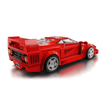 Miniatura de carro desportivo vermelho construído com blocos tipo LEGO, com detalhes transparentes e cinzentos.