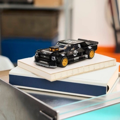 Miniatura de carro desportivo preto com rodas amarelas sobre livros
