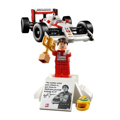 Brinquedo LEGO piloto de corrida com troféu, capacete, placa e carro branco e vermelho número 12 McLaren.