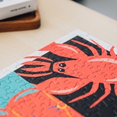 Quebra-cabeças com caranguejo vermelho e preto num fundo azul e branco