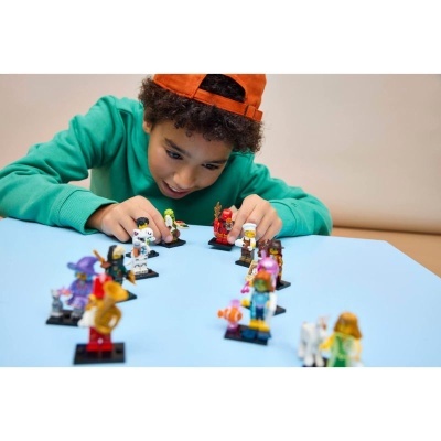Rapaz a brincar com figuras de brinquedo coloridas numa mesa azul