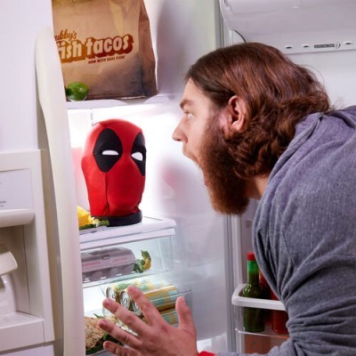 Miniatura da cabeça de Deadpool dentro do frigorífico aberto com um homem a olhar para ela