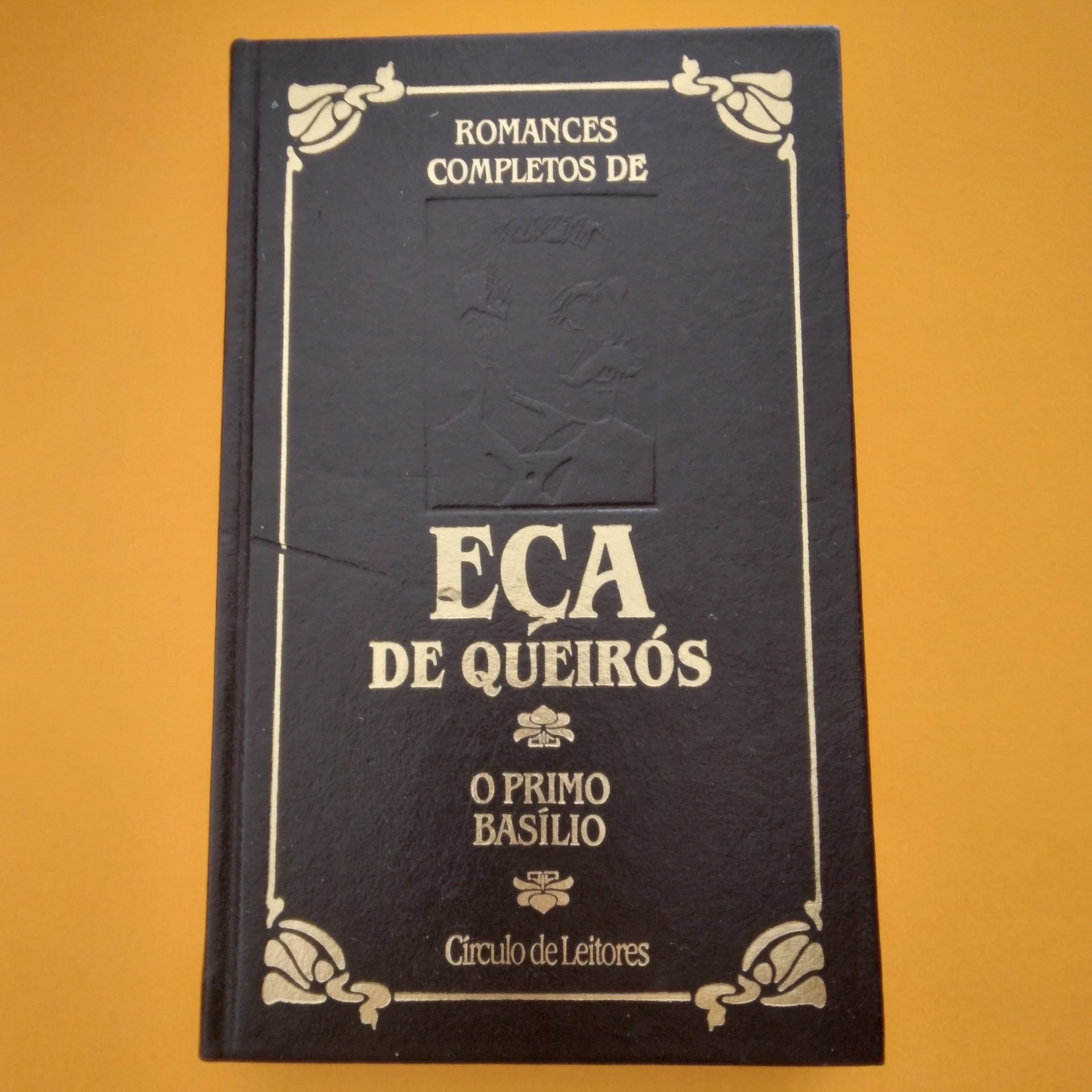 O Primo Basílio, Eça de Queirós Livro capa dura preta 'ROMANCES COMPLETOS DE EÇA DE QUEIRÓS' sobre fundo laranja
