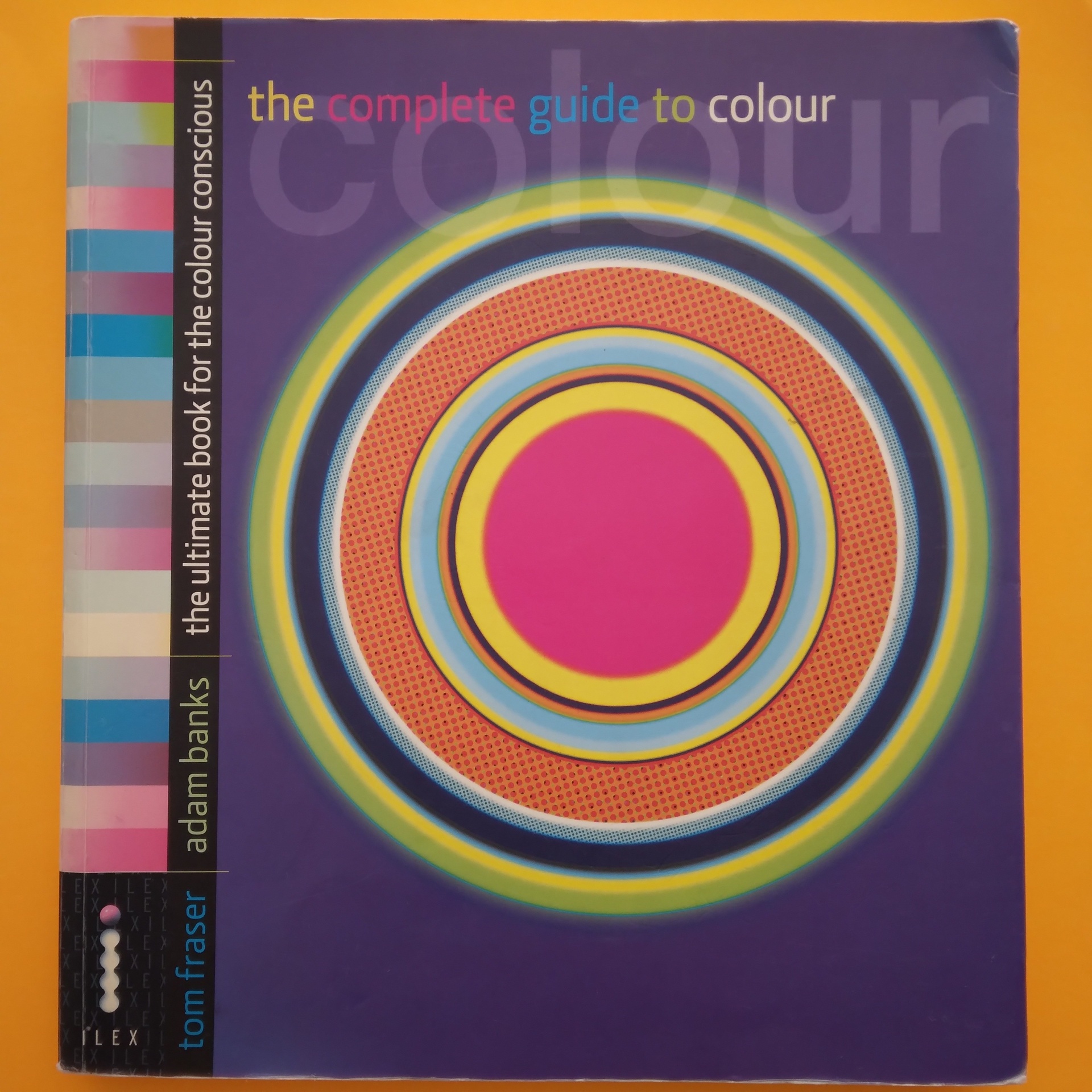 The Complete Guide To Colour, Tom Fraser e Adam Banks Livro 'the complete guide to colour' com capa colorida e design circular sobre fundo laranja.