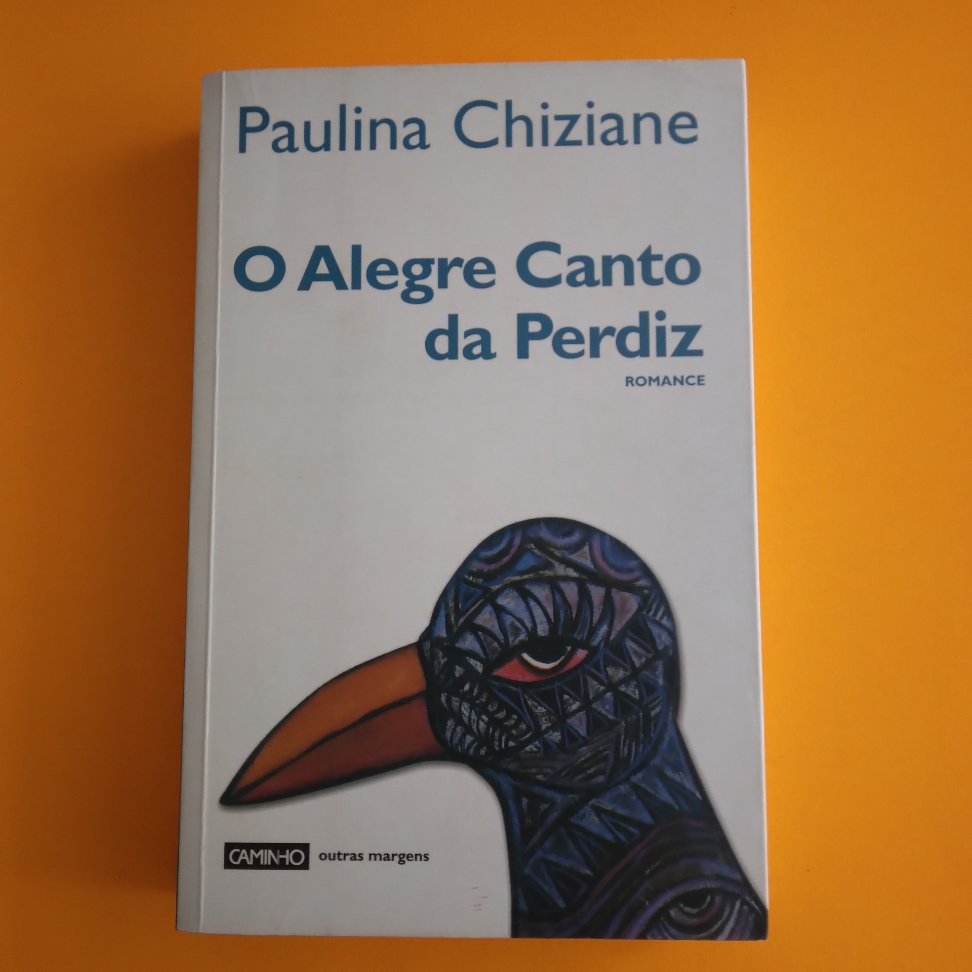 O Alegre Canto da Perdiz, Paulina Chiziane Capa de livro branco com título e ilustração de pássaro colorido.