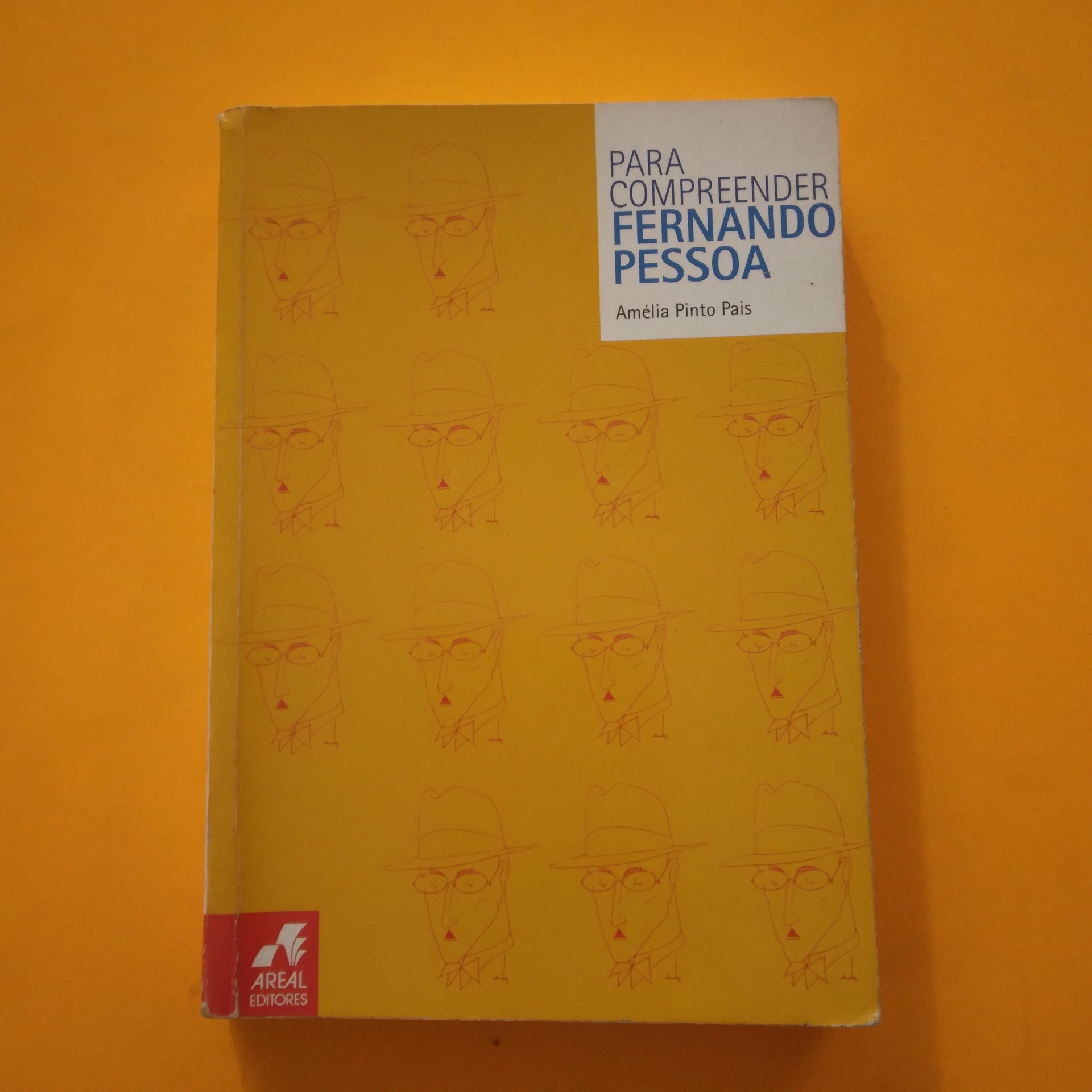 Para Compreender Fernando Pessoa, Amélia Pinto Pais Capa de livro amarelo com desenhos repetidos de rosto e texto 'PARA COMPREENDER FERNANDO PESSOA', fundo laranja