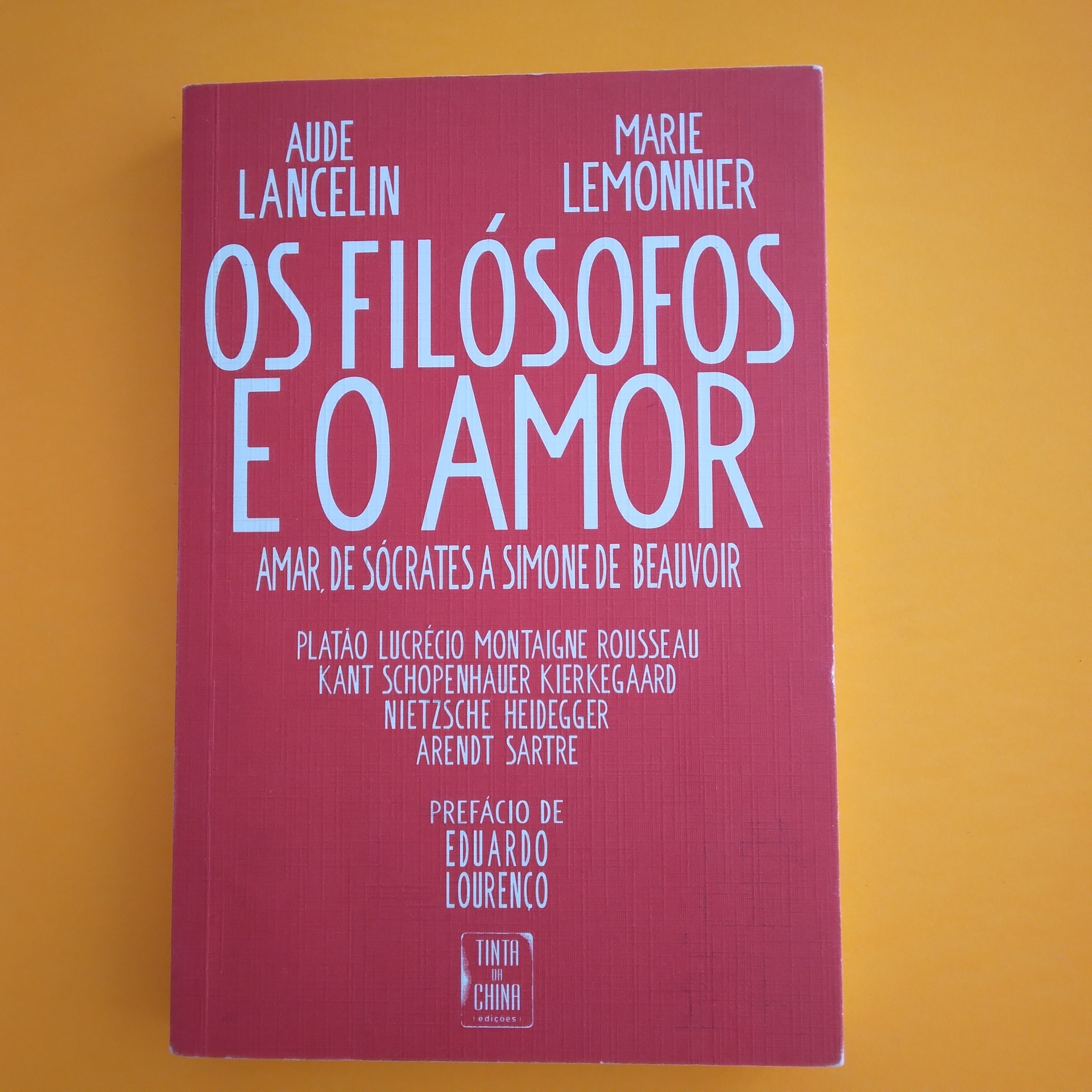 Os Filósofos e o Amor, Aude Lancelin e Marie Lemonnier Livro Os Filósofos e o Amor com capa vermelha sobre fundo laranja