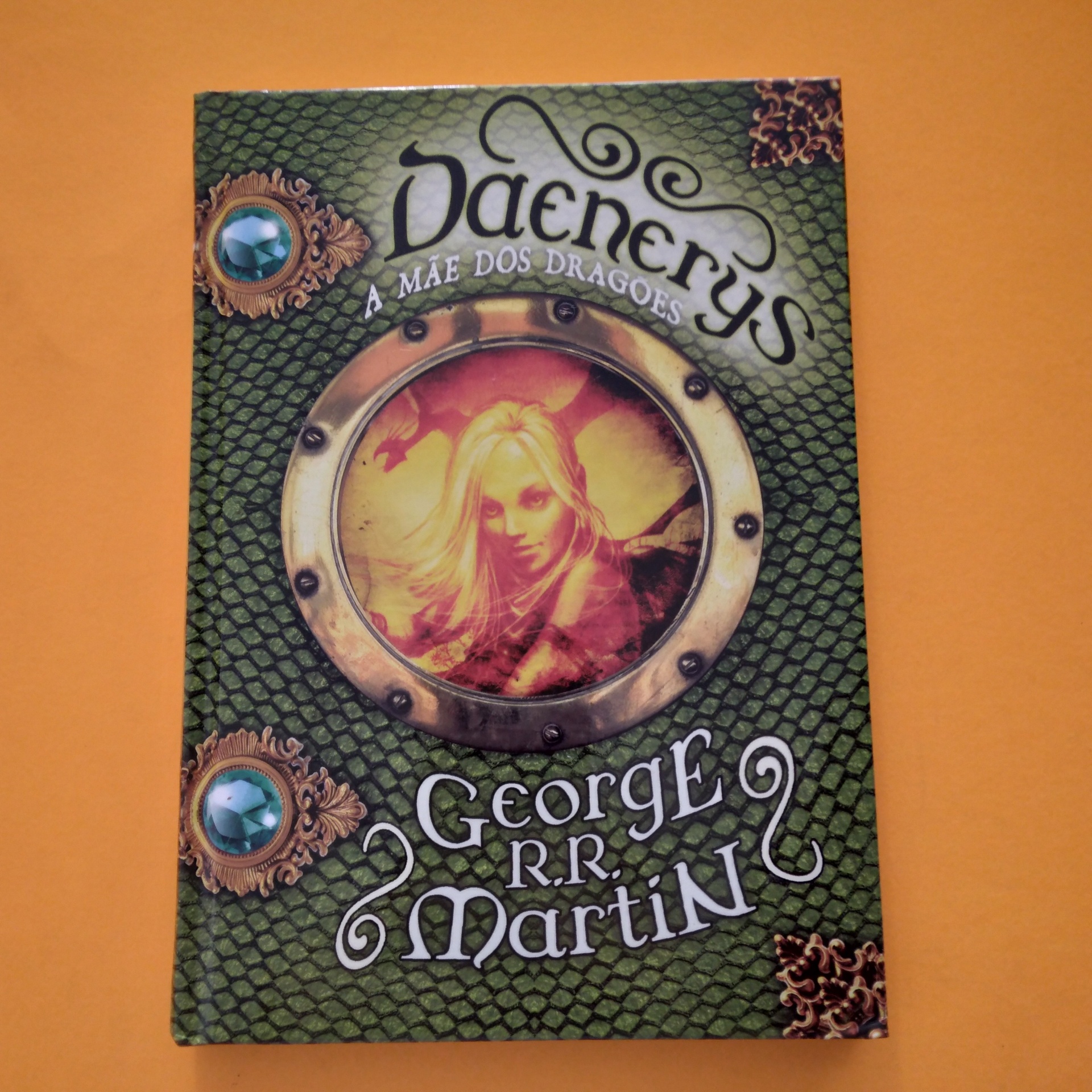 Daenerys. A Mãe dos Dragões, George R.R. Martin Capa de livro verde com escamas e foto circular de mulher loira