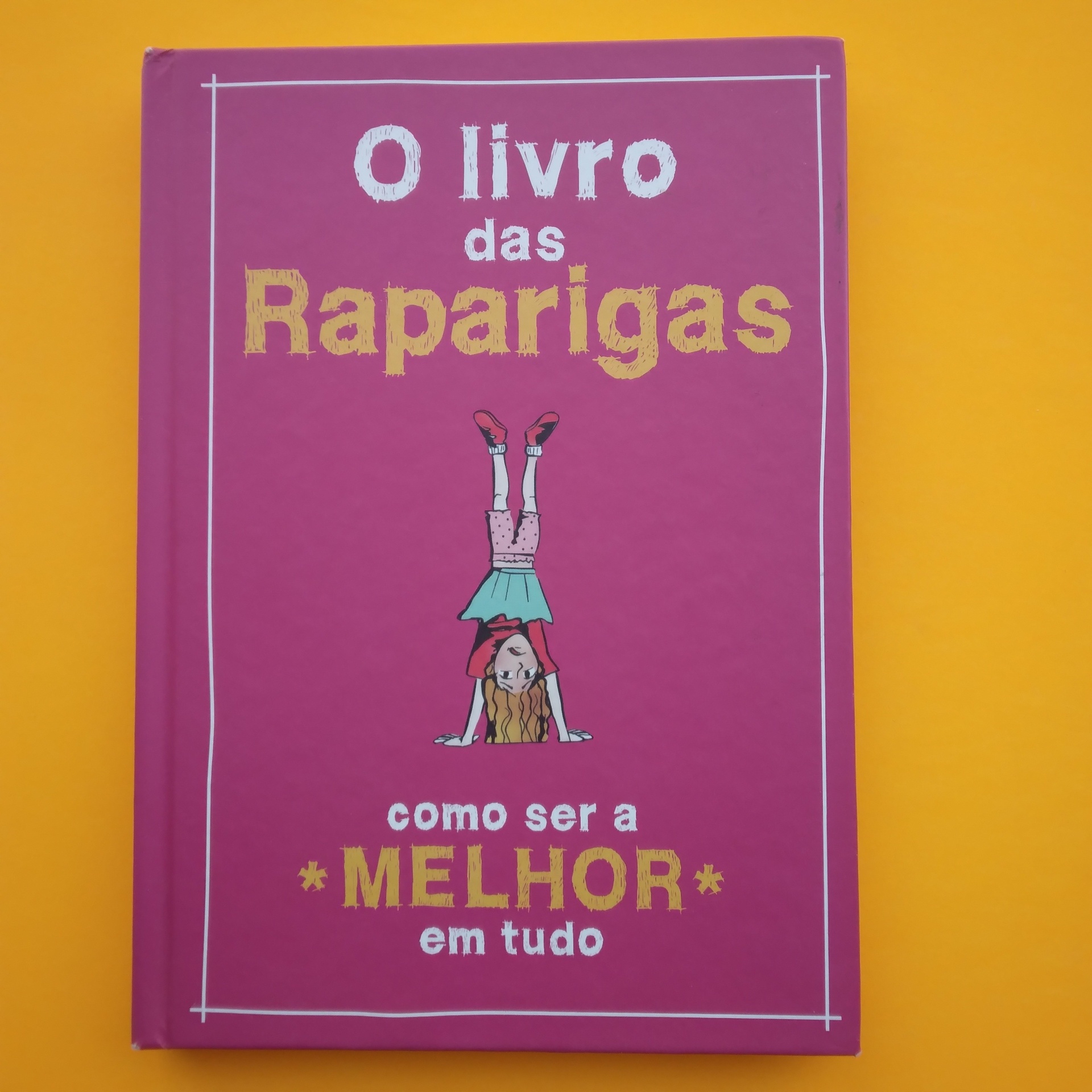 O Livro das Raparigas, Juliana Foster Capa de livro rosa com ilustração de rapariga e texto em branco e dourado