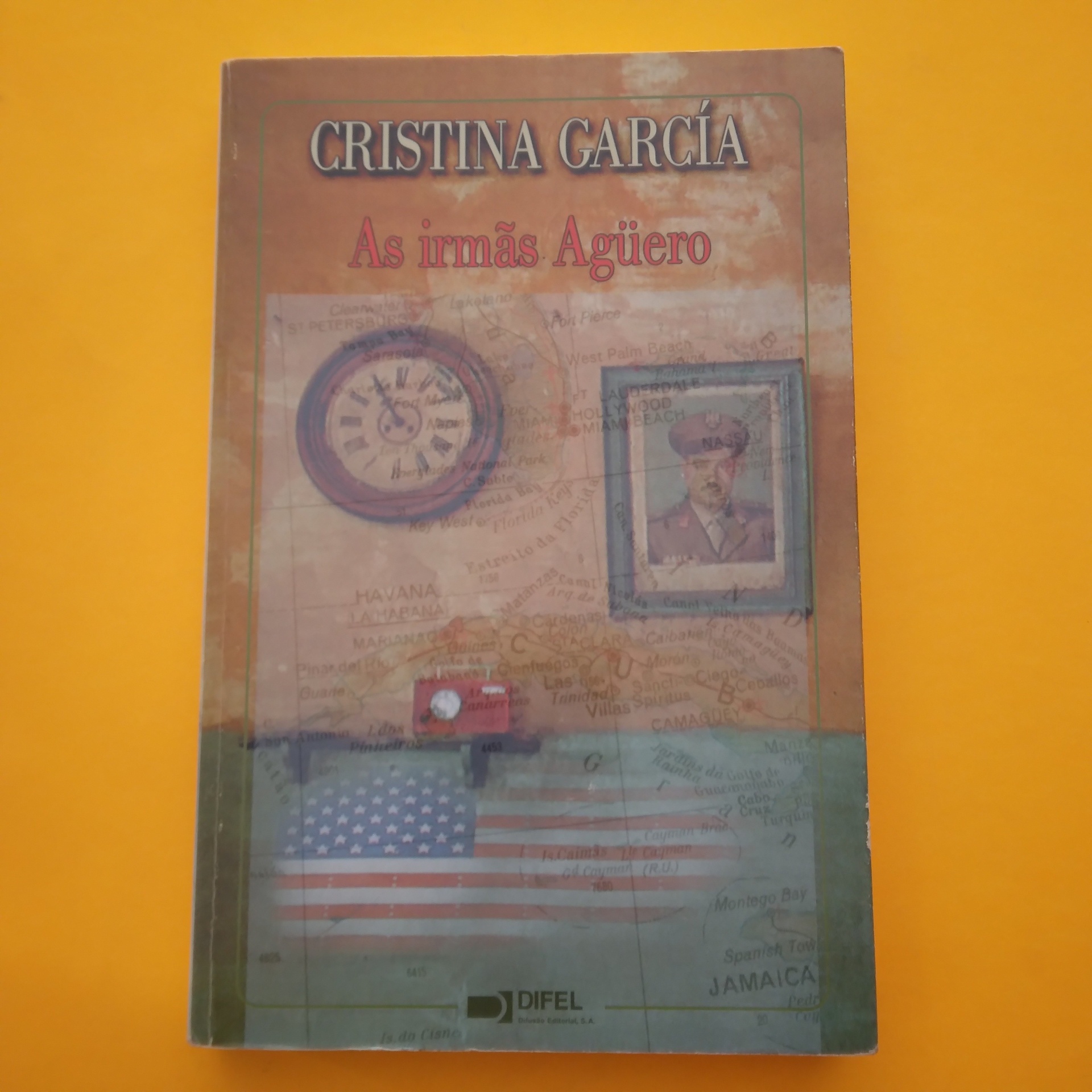 As Irmãs Agüero, Cristina García Capa de livro com relógio, fotografia de homem e bandeira dos EUA sobre mapa