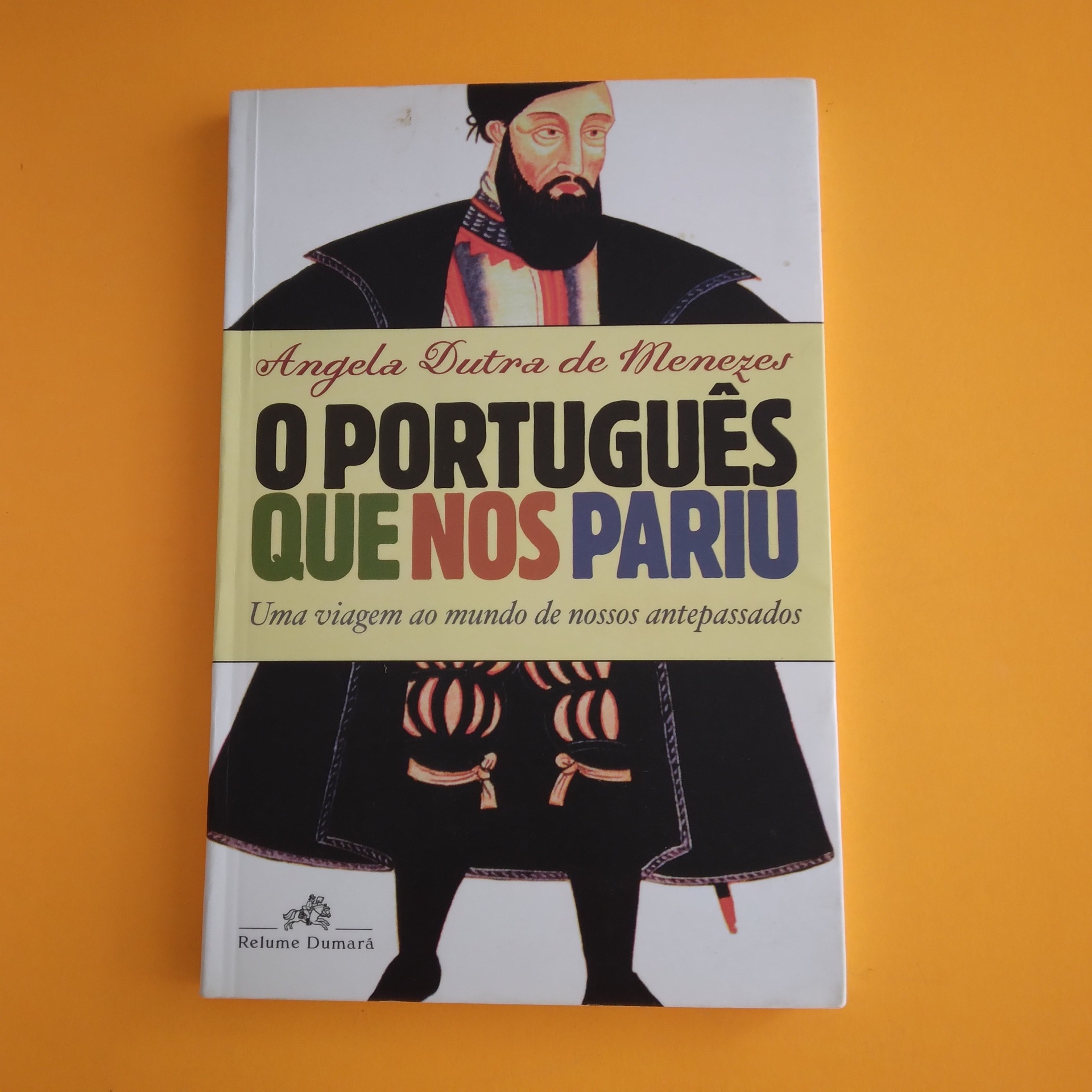 O Português que nos Pariu, Angela Dutra de Menezes Livro 'O Português Que Nos Pariu' com ilustração de homem histórico na capa.