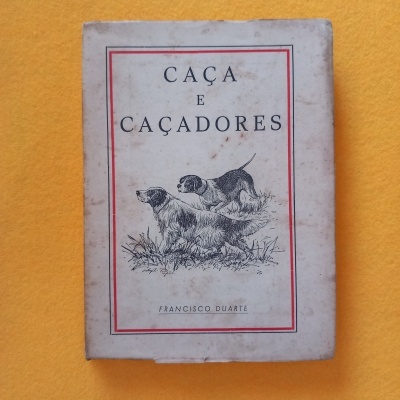 Capa de livro branco com ilustração de dois cães e texto 'CAÇA E CAÇADORES'.