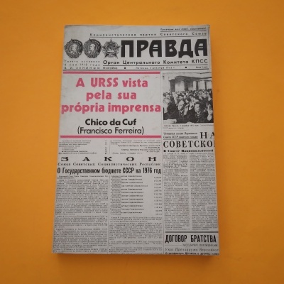Livro com capa imitando a primeira página do jornal 'PRAVDA' da URSS, texto em russo e português, fundo laranja.
