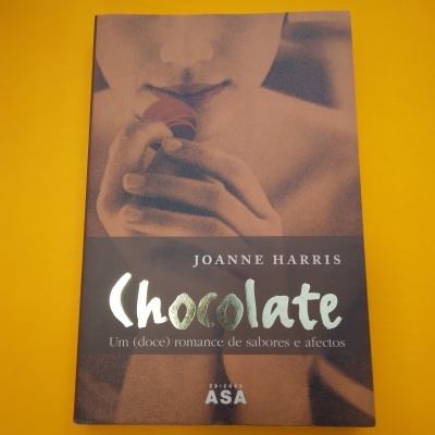 Capa do livro 'Chocolate' de Joanne Harris com imagem desfocada de pessoa segurando chocolate