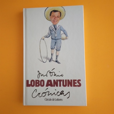 Capa de livro 'Crónicas' de Lobo Antunes com ilustração de homem com roupa azul e chapéu de palha