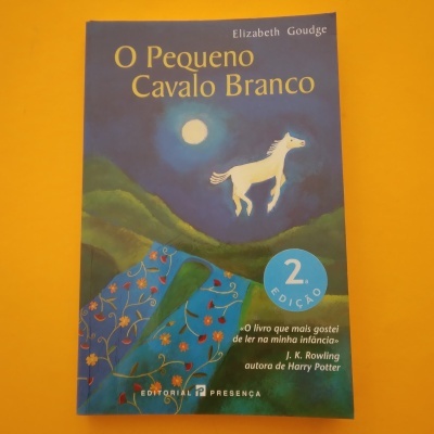 Capa do livro 'O Pequeno Cavalo Branco' com ilustração de cavalo branco sob lua cheia e manto florido