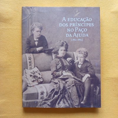 Capa de livro com fotografia antiga em preto e branco de mulher e duas crianças sentados num sofá e o título do livro em letras brancas.