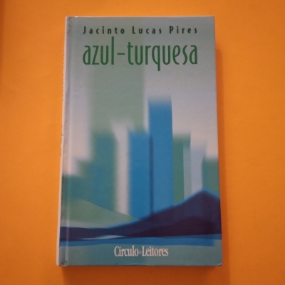 Livro azul-turquesa sobre superfície laranja
