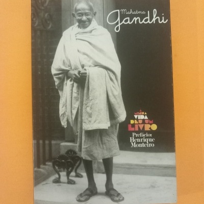 Livro com capa com fotografia de Mahatma Gandhi e textos