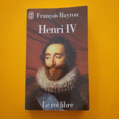 Livro 'Henri IV' com retrato de homem com colarinho rendado, fundo amarelo.