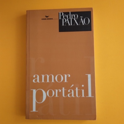 Livro amor portátil de Pedro Paixão sobre superfície amarela