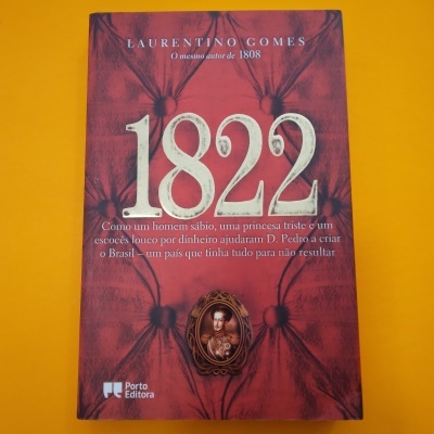 Livro 1822 de Laurentino Gomes com capa vermelha texturizada sobre fundo laranja