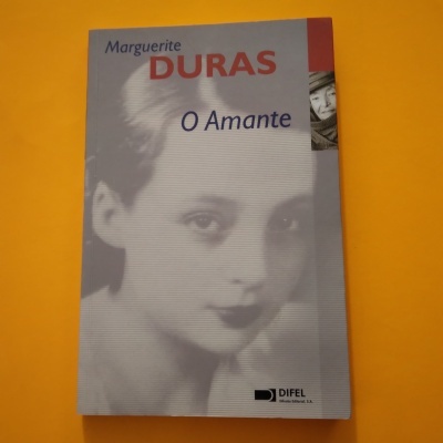 Capa do livro 'O Amante' de Marguerite Duras com imagem de jovem mulher em tons cinza