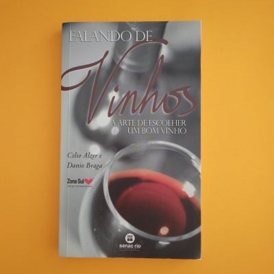 Capa de livro cinzenta com copo de vinho tinto e texto do título e autores
