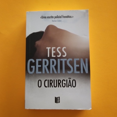 Capa do livro 'O Cirurgião' de Tess Gerritsen com fundo cinzento e texto em azul e preto