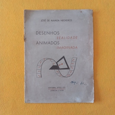 Livro antigo 'Desenhos Realidade Animados Imaginada' com capa cinzenta e texto em preto e vermelho
