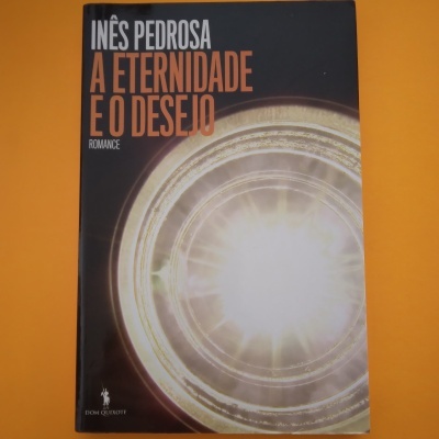 Livro 'A ETERNIDADE E O DESEJO' de Inês Pedrosa com capa preta e círculo brilhante