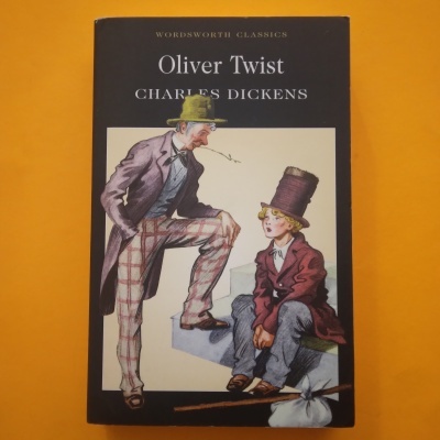 Capa do livro Oliver Twist de Charles Dickens com ilustração de duas figuras masculinas e fundo laranja