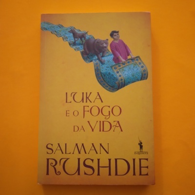 Livro 'L'UKA E O FOGO DA VIDA' de Salman Rushdie com ilustração de tapete mágico e animais