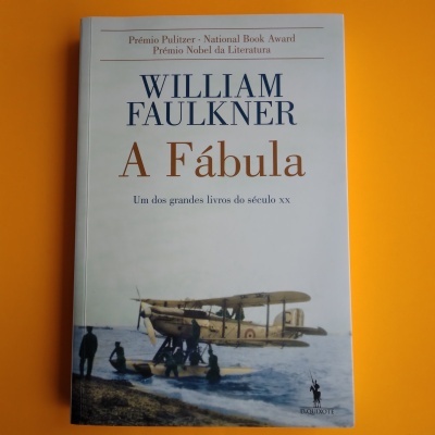 Capa do livro 'A Fábula' de William Faulkner com imagem de hidroavião e pessoas na água.