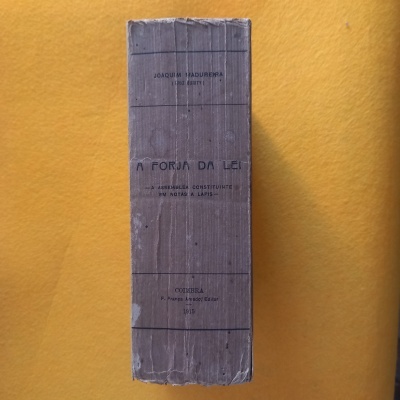 Livro antigo A Forja da Lei com capa castanha clara e texto legível na lombada