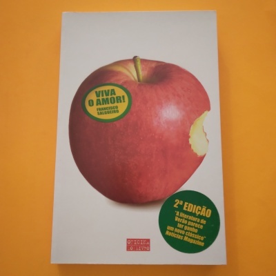 Capa de livro com maçã vermelha mordida e autocolantes verdes com texto