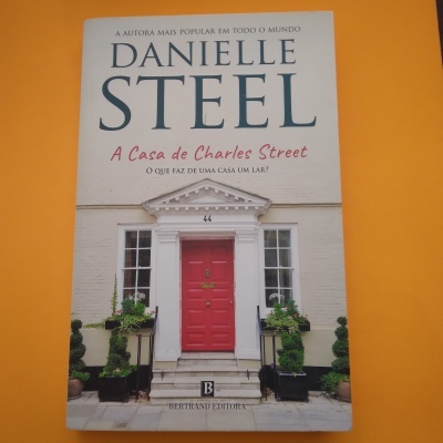 Capa do livro A Casa de Charles Street de Danielle Steel com porta vermelha e plantas