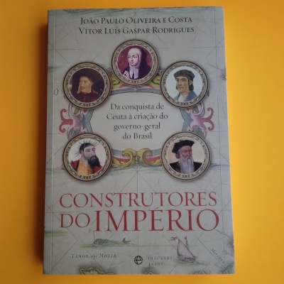 Capa de livro 'Construtores do Império' com retratos e texto em fundo com mapa antigo
