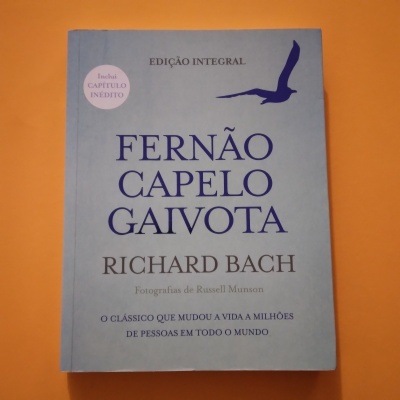 Capa do livro Fernão Capelo Gaivota com fundo azul e texto em azul e preto
