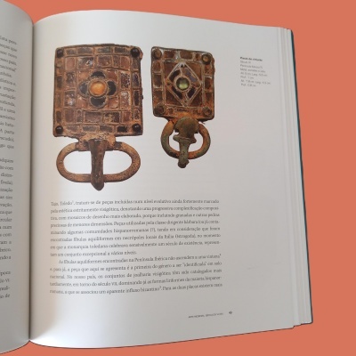 Placas de cinto metálicas medievais quadradas com esmaltes e pedras em livro aberto.